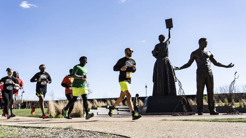 Run Richmond 1619 race 2022 passes the freedom and emancipation statues on Brown's Island, Richmond, Virginia. “What’s Booming RVA: Diverse Events, Diverse Communities.”