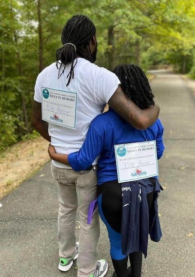 Grieving family members in an embrace, participating in the Miles in Memory annual walk hosted by Full Circle grief center.