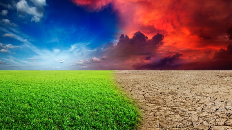 climate change concept image, with green on one side and parched bare ground and burning mountains on the other.