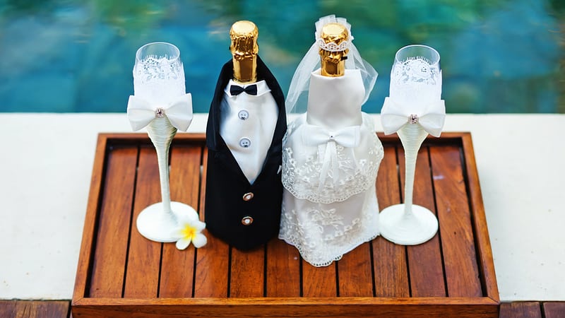 wedding decoration with Champagne bottles dressed up as bride and groom, by Milaapid. For article on a controlling Momzilla mother-in-law