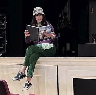 Illeana Douglas sitting on the stage of the Katharine Hepburn Cultural Arts Center, with an early draft copy of Connecticut in the Movies - photo Nick Thomas