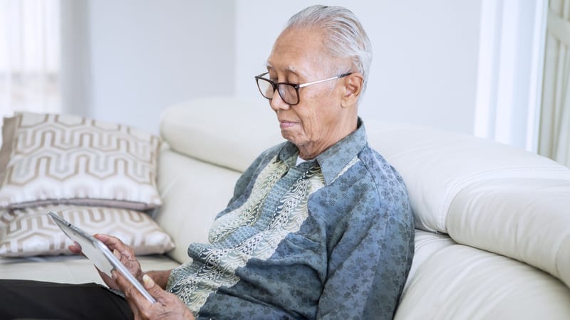 An Asian man on his electronic tablet