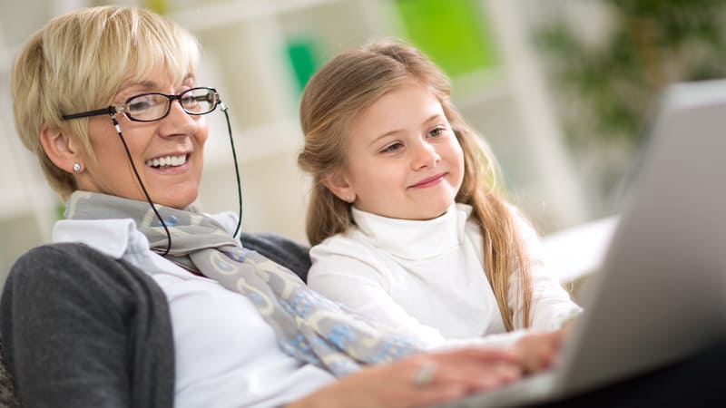 grandmother and granddaughter on a laptop, by Igor Mojzes. Used with Jumble puzzles for kids and adults, inc. one with "kitty love"