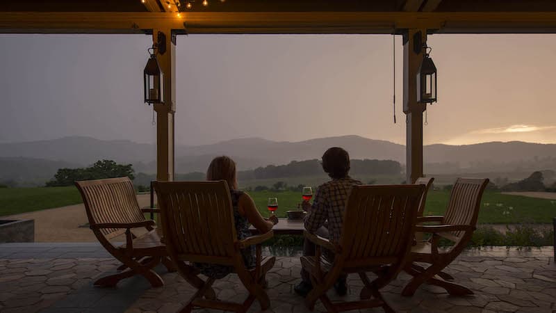 Two friends drinking wine and enjoying sunset at Pippin Hill Farm and Vineyards, part of the Monticello AVA