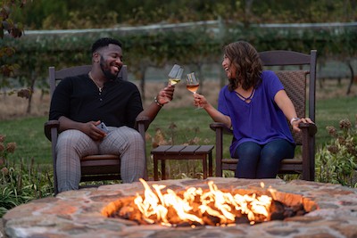 A couple enjoying wine beside a fire pit at Southwest Mountains Vineyards. Monticello AVA Wins International Acclaim