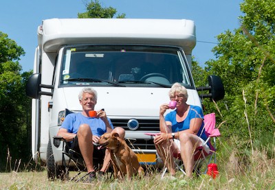 a couple RV camping with their dog, by Ivonne Wierink