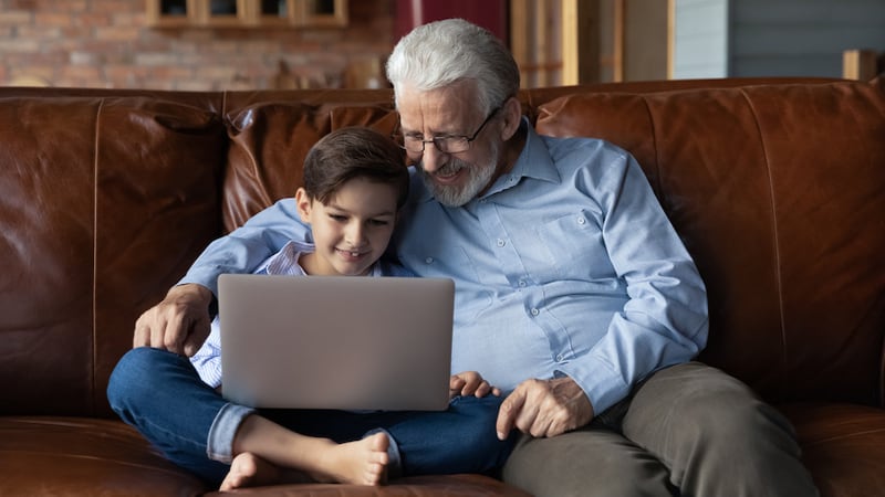 granddad and grandson on a laptop, perhaps playing a puzzle