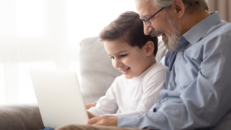 A granddad and a grandson looking at a laptop, by Fizkes. For Jumble puzzles - two, one for kids and one Classic