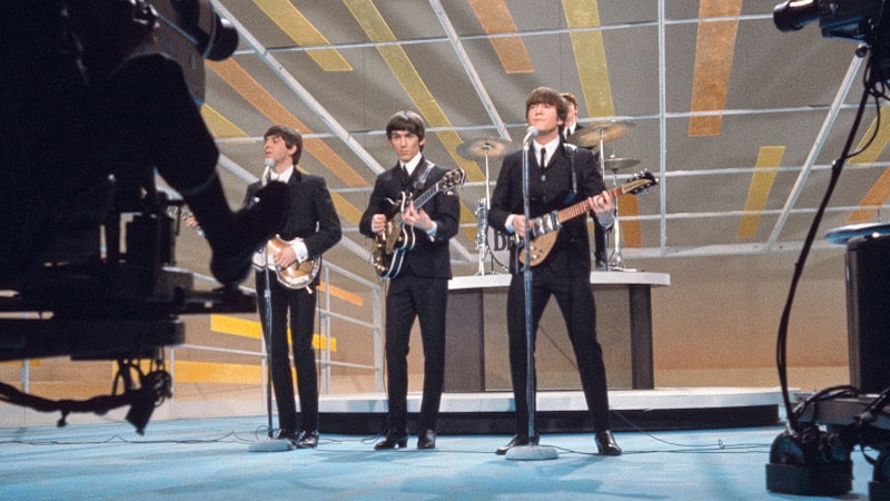 English Rock Band The Beatles, from left Paul McCartney, George Harrison, John Lennon, Ringo Starr performing on the Television Variety Series, "The Ed Sullivan Show", New York City, New York, USA, Bernard Gotfryd, February 1964. Article: The Beatles and Boomers