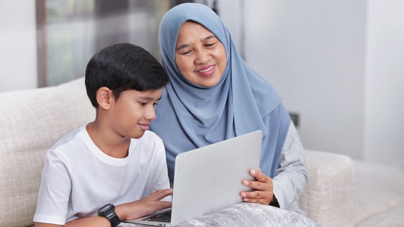 Grandmother and grandson on a laptop, possibly doing a puzzle, like Jumble puzzles.