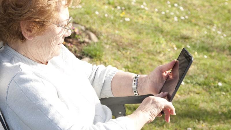 woman with small tablet. Image by Prudencio Alvarez. For Boggle mammal hunt puzzle at BoomerMagazine.com