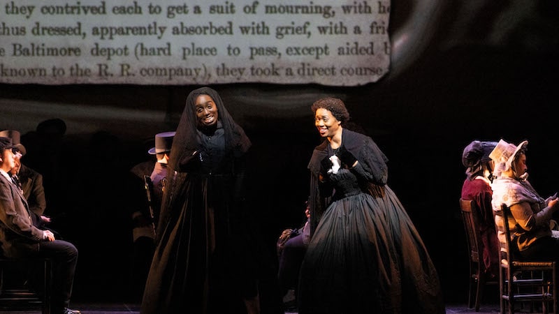 : Tesia Kwarteng and Laquita Mitchell as Harriet Eglin and Charlotte Giles escaping enslavement by pretending to attend the funeral of their fictional family member, Aunt Abigail. Image by Dave Pearson.