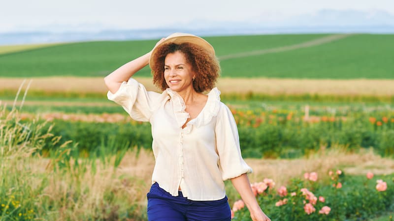 Beautiful picky single woman outside in a field of flowers. Image by Annanahabed