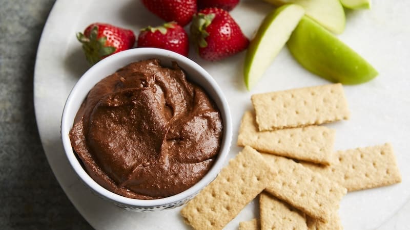 This dark chocolate hummus is an unexpectedly delightful treat, for dessert or a snack, that still packs the protein and fiber punch of traditional hummus. Try dipping banana and apple slices, pretzels, strawberries or graham crackers in this sweet, chocolaty spread. You can serve it with fruit and graham crackers.