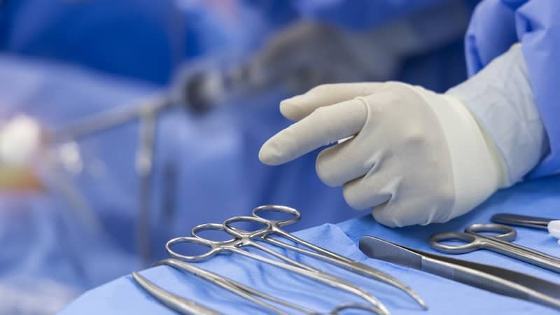 surgical instruments and a surgeon's gloved hand. For article on unnecessary body parts, some that are even removed.