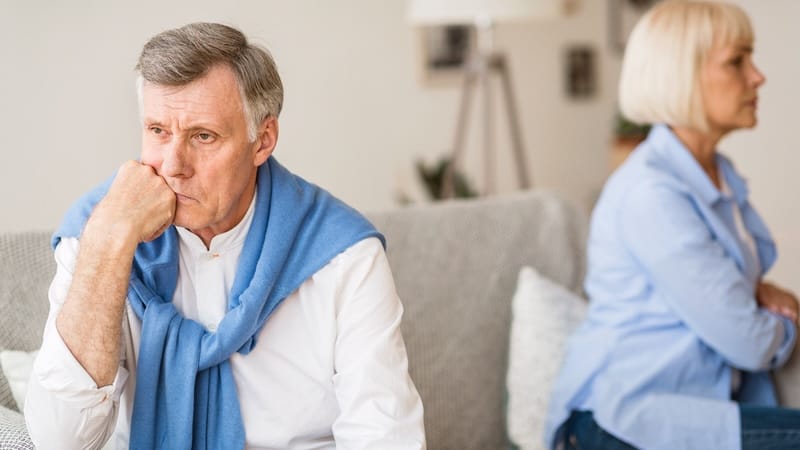 A husband and wife on the sofa with backs to each other, angry. By Prostockstudio. Article on a wife who has issues a 'no sex' ultimatum.