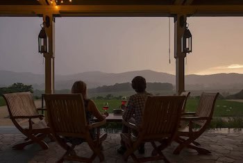 A couple drinking wine and looking out over the mountains at Pippin Hill Farm & Vineyards, Virginia