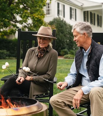 A couple roasting marshmallows at a fire pit in front of the Clifton manor house