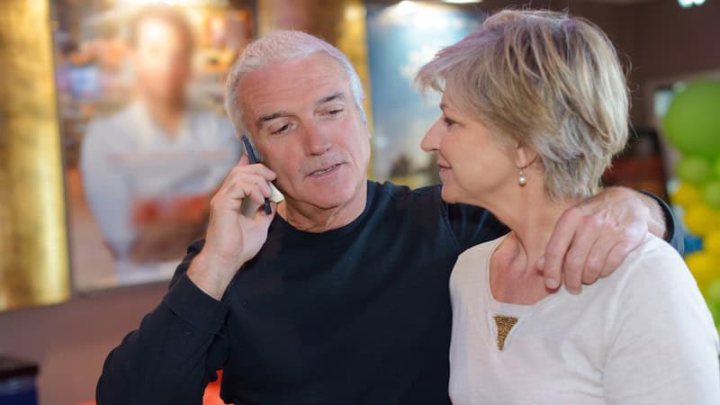 Couple at an art gallery with the husband talking on his phone, getting apologies from his son because he and his wife are serial cancelers.