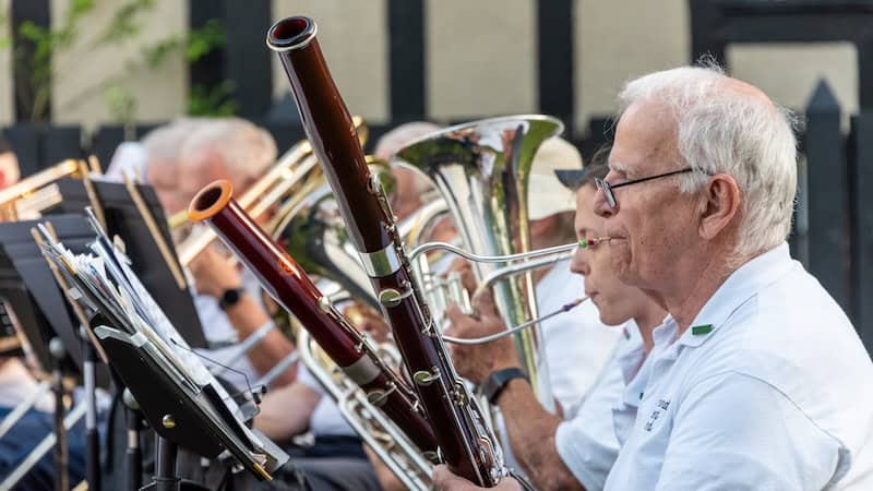 Concert band at Agecroft Hall. Image by Stratton McCrady. What's Booming: Author Ron Moody and Queen