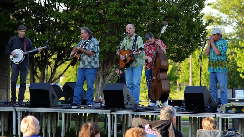 Bluegrass band outside on a stage. By Calvin L. Leake. Used with What's Booming RVA: ‘¿Qué Pasa, Sylvia?’