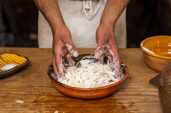 Hands working with re-created colonial foods in Colonial Williamsburg.