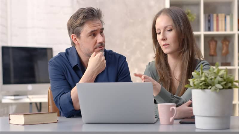 A couple at home looking at something on a laptop, like social media connections with the past. Image by Nyul