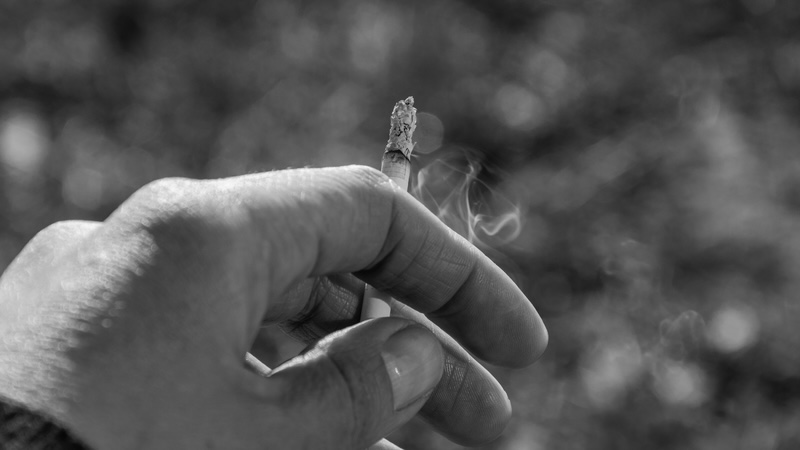 A hand holding a cigarette, demonstrates the concept of a "tarnished finger" – Image by Alikaj2582