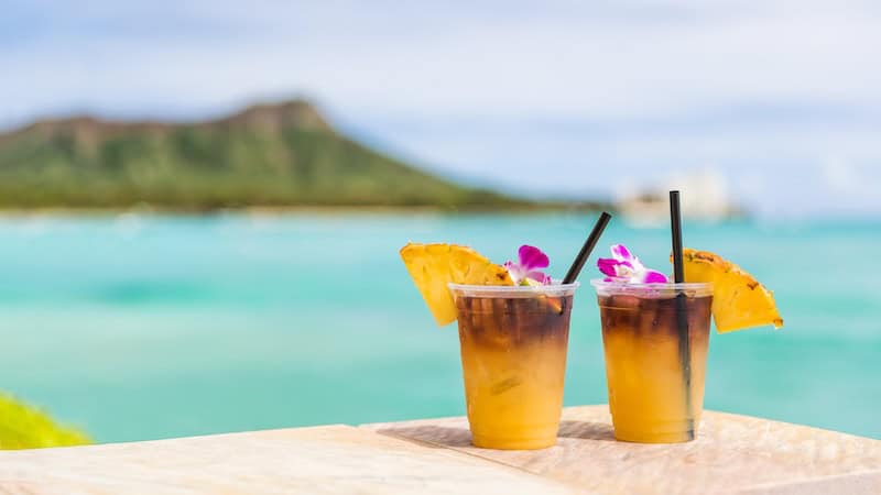 Two cocktails in a tropical-like setting, demonstrating alternative travel destinations.