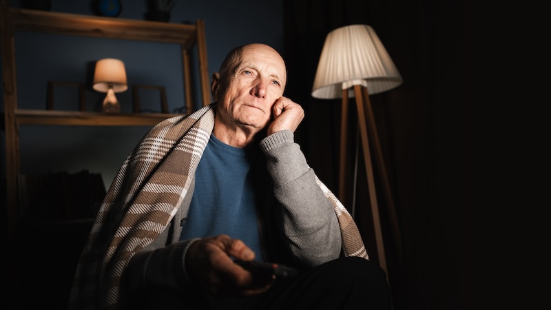 Lazy retired man watching TV in the dark room - the retired husband has changed. Image by Andrei Lysenko