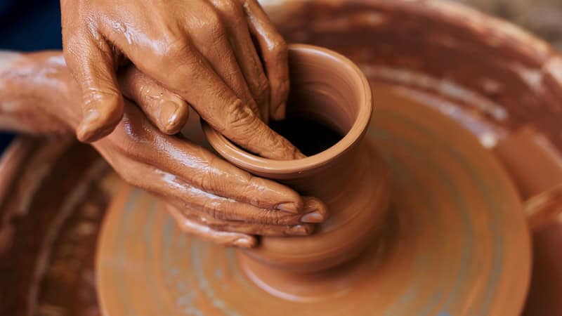 A potter creating a clay pot on a wheel. By pressmaster. Used with What's Booming: Comedy and Clay