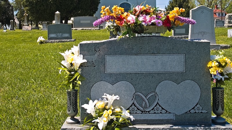 An uninscribed gravestone, ready for married couples names. A happy husband wants to be buried with his second wife, but he suspects the stepkids will object. Should they be able to dictate the parents’ burial plans?