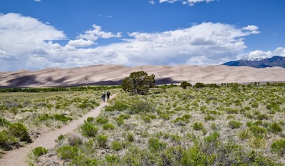 A couple take the half-mile sandy trail behind the Visitor Center to the dunes - Nick Thomas