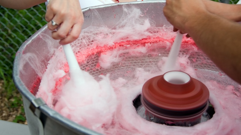 Two people make cotton candy, for throwbacks and memories. Image by Paul Hakimata