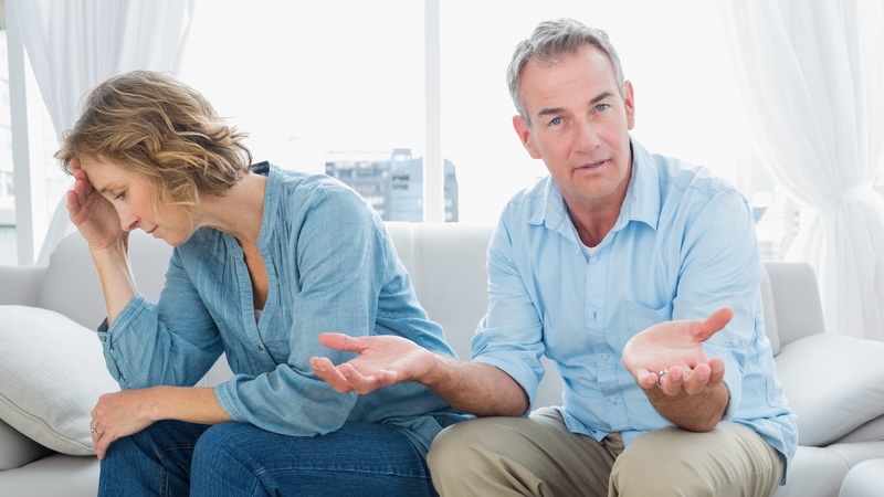A couple having an argument at home, such as over the husband’s emotional affair. By wavebreakmedia ltd