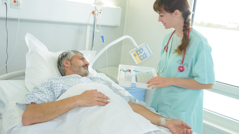 A man in the hospital bed with a nurse checking on him. Post on a disrespectful nurse. Image by Auremar