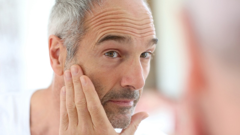 A man going through the routine to check for skin cancer. Image by Goodluz