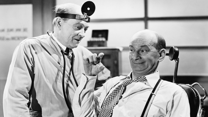 Old black and white image of a man with a doctor, image by Everett Collection. Used with Greg Schwem essay on medical jargon: “Doctor, please spare me the terminology”