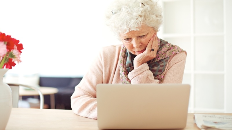 Woman on a laptop puzzling over the answer to Boggle count the countries or other puzzle. Image by Ammentorp