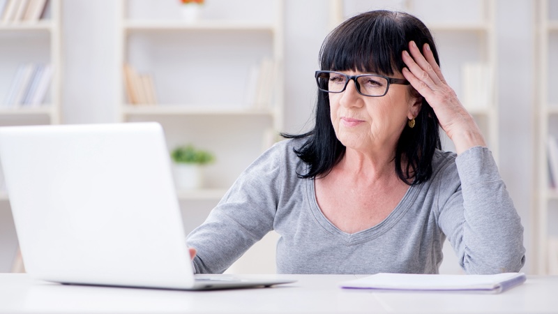 A woman frustrated at what she sees on her laptop computer, perhaps expressing her online dating woes. Image by Elnur