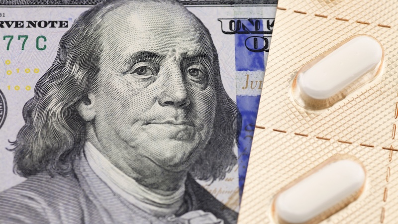 The headshot of Benjamin Franklin on a $100 bill besides some medication in pill packs. Article on higher Medicare costs