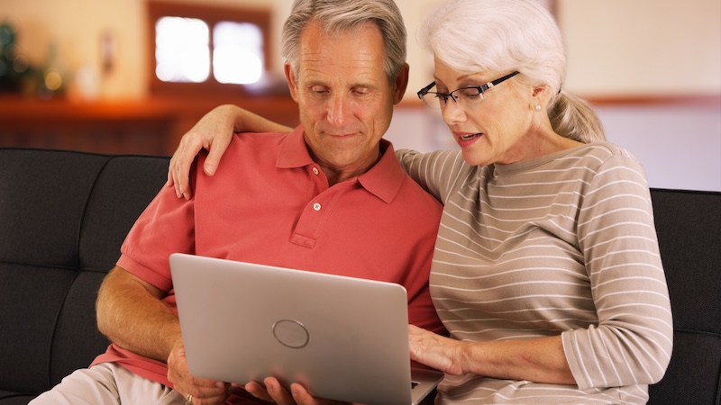 couple on a laptop, perhaps playing the Boggle puzzle of four-letter mammals.