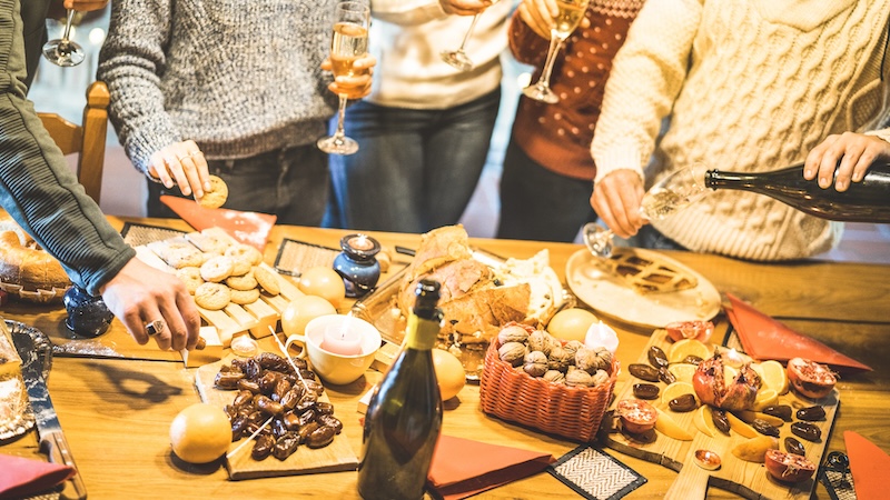 A holiday table of food and drink, by Mirko Vitali. Used with an article on a party pooper who criticizes food and drink choices at parties.