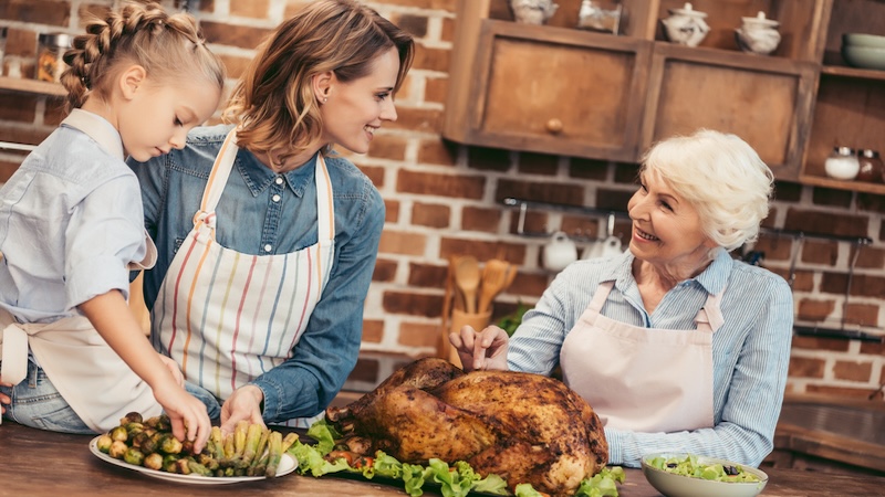 Three generations in the kitchen talking turkey for a holiday meal.