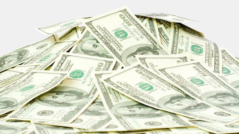 A pile of 100-dollar bills. Are you saving too much for retirement? Sometimes, all that diligent saving can actually cause more financial harm than good. (Dreamstime/TCA)