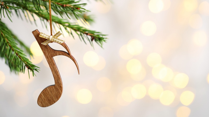 Evergreen tree branch tips with a musical note ornament hanging down. By Chernetskaya. For What's Booming: 'Tis the Season of Music