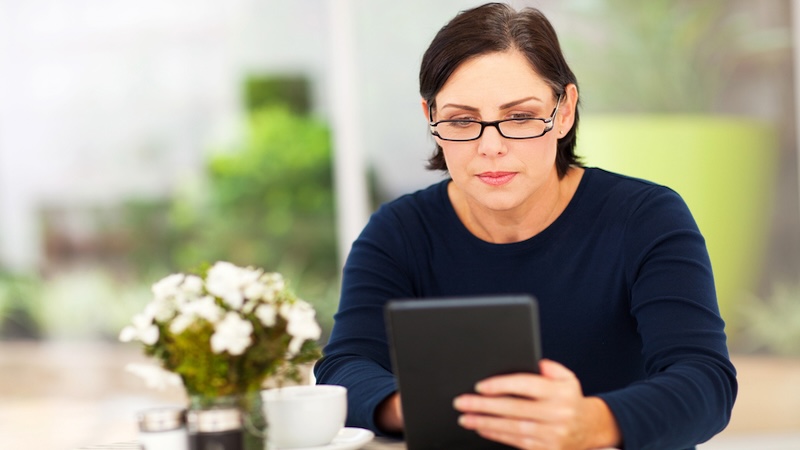 Woman on tablet, possibly playing Boggle the land formations or other puzzle. Image by Michael Zhang