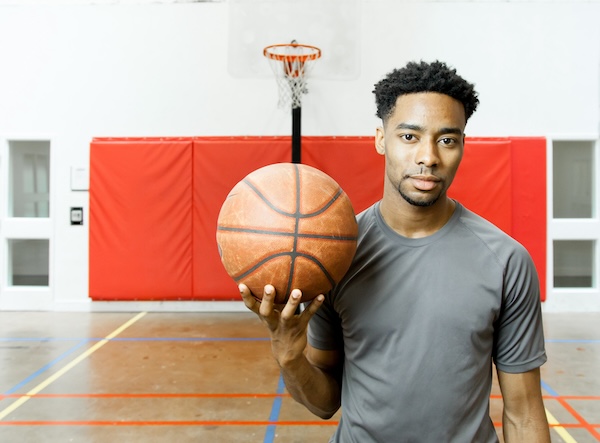 A young male basketball player in a school gymnasium. For What's Booming February 5