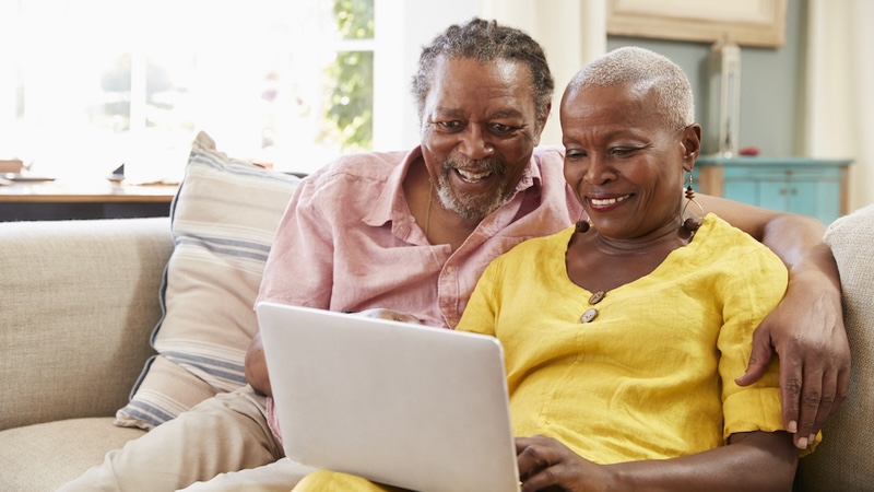 Couple on laptop, possible playing puzzles like Boggle