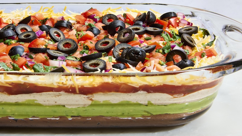 Seven-layer dip, a party staple, is everything you love about a taco, from the refried beans and guac to sour cream and pico de gallo, served dip-style. (Ryan Liebe/TCA)